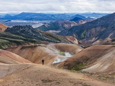 Hiker on the trail through the coloured rhyolite mountains near Landmannalaugar