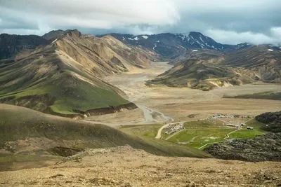 Wide view over the Landmannalaugar valley with the campsite, braided river and coloured mountains